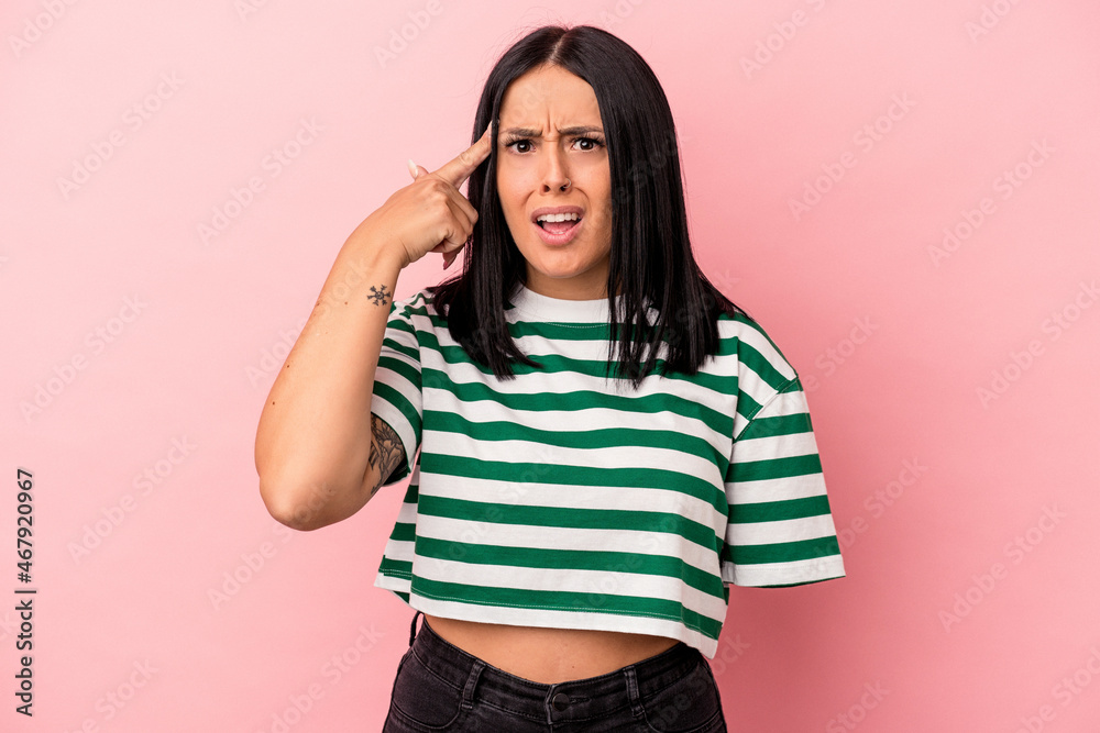 Young caucasian woman with one arm isolated on pink background showing a disappointment gesture with forefinger. Young caucasian woman with one arm isolated on pink background showing a disappointment gesture with forefinger.