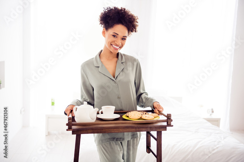 Portrait of attractive cheerful wavy-haired girl eating tasty yummy meal serving table at light white home house indoors