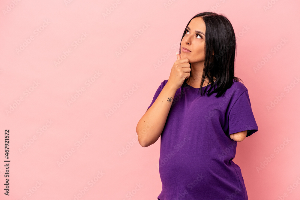 Young pregnant woman with one arm isolated on pink background looking sideways with doubtful and skeptical expression. Young pregnant woman with one arm isolated on pink background looking sideways with doubtful and skeptical expression.