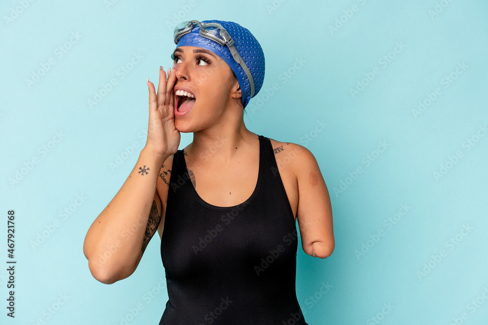 Young swimmer caucasian woman with one arm isolated on blue background shouting and holding palm near opened mouth. Young swimmer caucasian woman with one arm isolated on blue background shouting and holding palm near opened mouth.