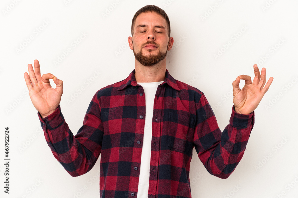 Young caucasian man with diastema isolated on white background relaxes after hard working day, she is performing yoga. Young caucasian man with diastema isolated on white background relaxes after hard working day, she is performing yoga.