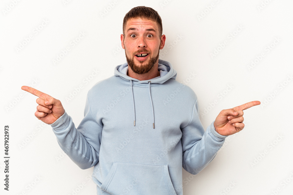 Young caucasian man with diastema isolated on white background pointing to different copy spaces, choosing one of them, showing with finger. Young caucasian man with diastema isolated on white background pointing to different copy spaces, choosing one of them, showing with finger.