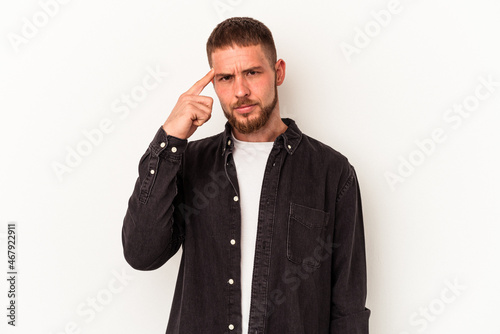 Young caucasian man with diastema isolated on white background pointing temple with finger, thinking, focused on a task.