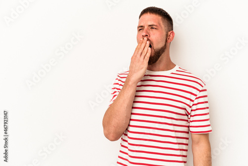 Young caucasian man with diastema isolated on white background yawning showing a tired gesture covering mouth with hand.