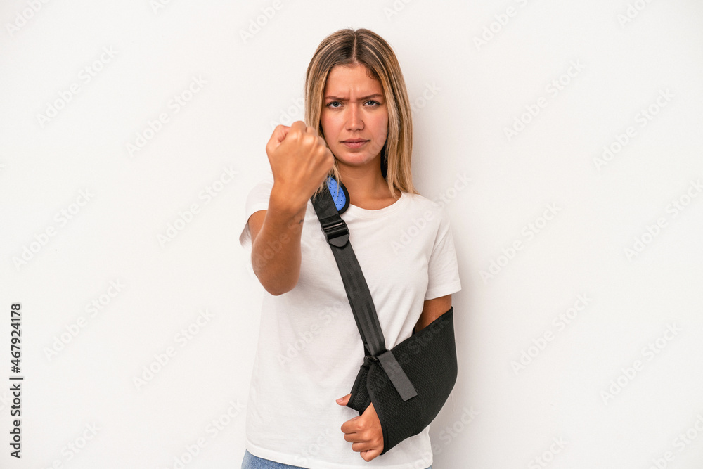 Young caucasian woman with broken hand isolated on white background showing fist to camera, aggressive facial expression. Young caucasian woman with broken hand isolated on white background showing fist to camera, aggressive facial expression.