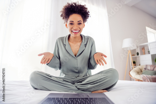 Portrait of attractive cheerful girl using laptop calling friend on web discussing news at light white home indoors