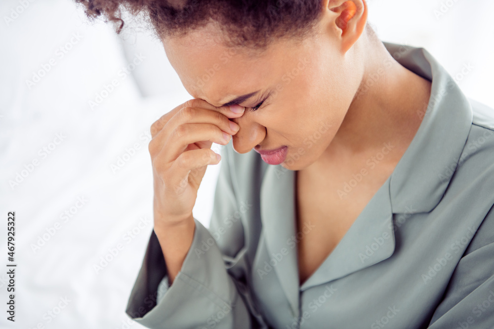 Cropped view portrait of attractive depressed girl suffering chronic pain hurt touching nose at light white home indoors Cropped view portrait of attractive depressed girl suffering chronic pain hurt touching nose at light white home indoors