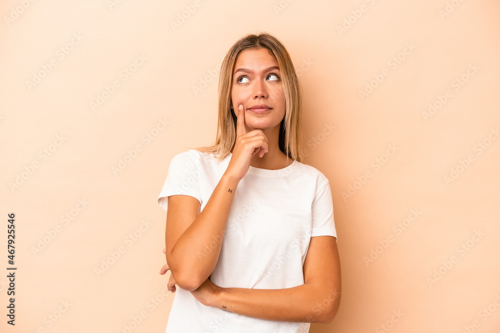 Young caucasian woman isolated on beige background contemplating, planning a strategy, thinking about the way of a business. Young caucasian woman isolated on beige background contemplating, planning a strategy, thinking about the way of a business.