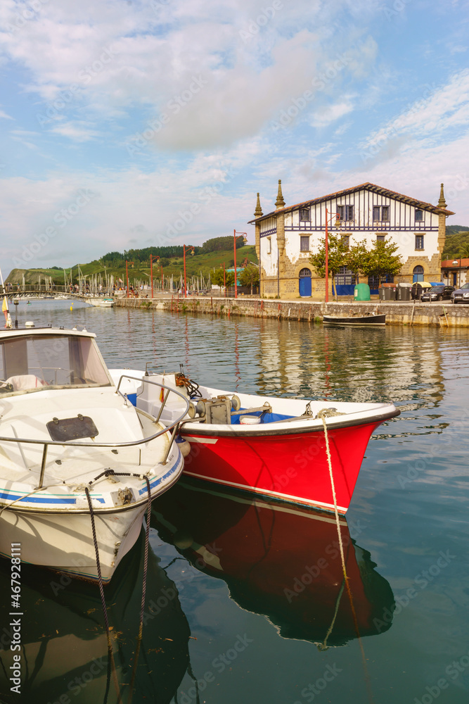 Side view of fishing boats resting in Narrondo river in the spanish city of Zumaia. Horizontal view of fishing town landscape in the Vasque country. Travel destination in Spain.