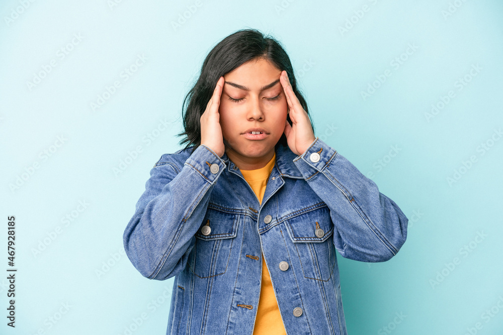 Young latin woman isolated on blue background touching temples and having headache.