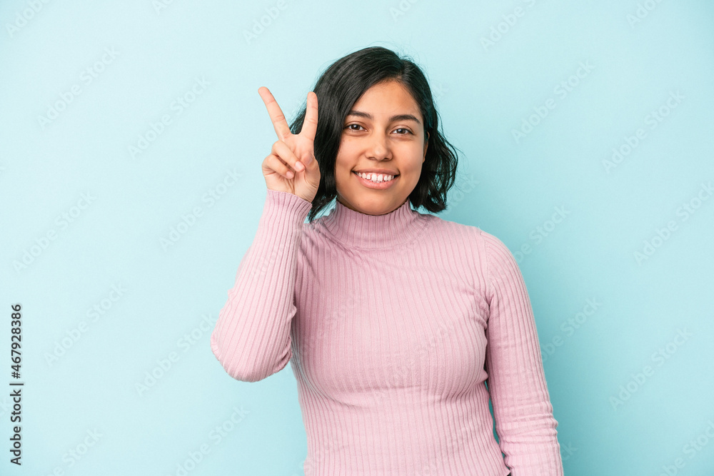 Young latin woman isolated on blue background showing number two with fingers. Young latin woman isolated on blue background showing number two with fingers.