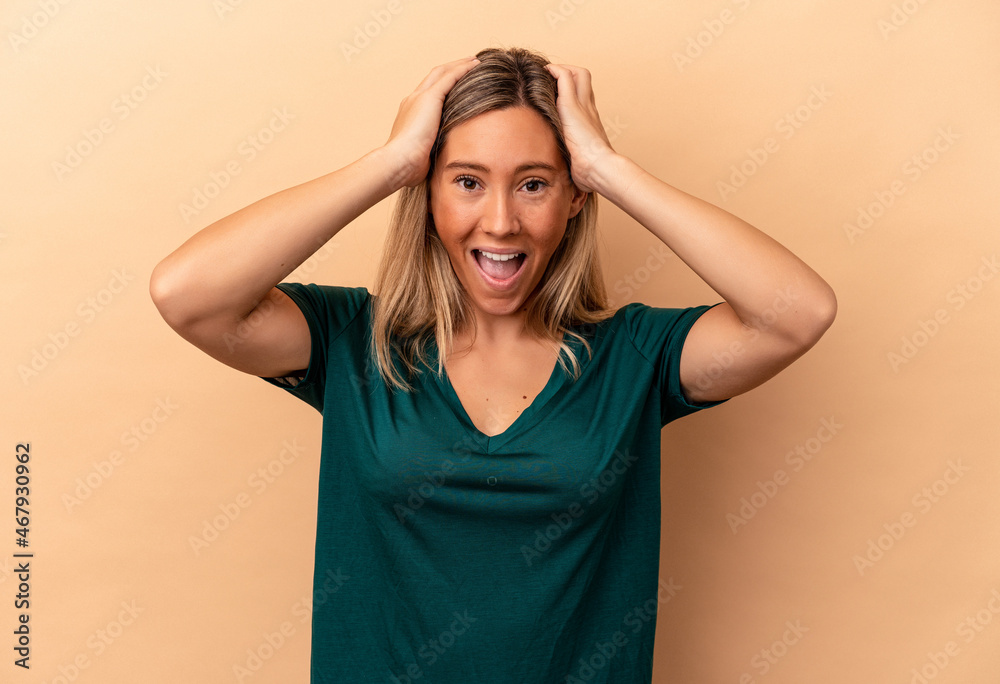 Young caucasian woman isolated on beige background screaming, very excited, passionate, satisfied with something. Young caucasian woman isolated on beige background screaming, very excited, passionate, satisfied with something.