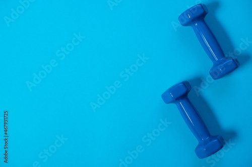fitness sport concept. Blue dumbbells on Blue background. Sport equipment background for healthy