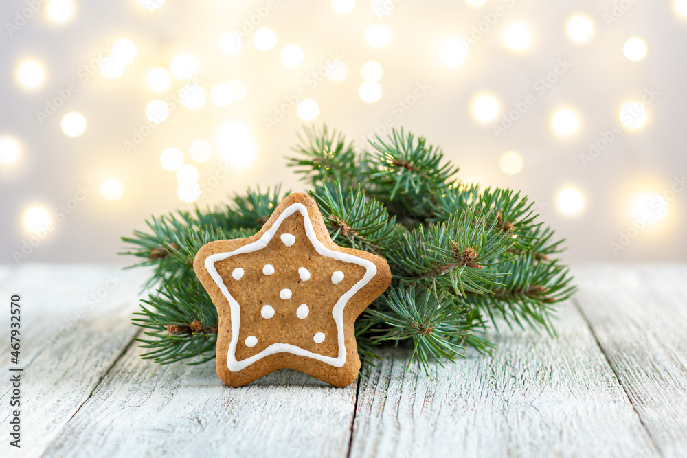 Gingerbread star with fir tree branch on bokeh lights background Gingerbread star with fir tree branch on bokeh lights background