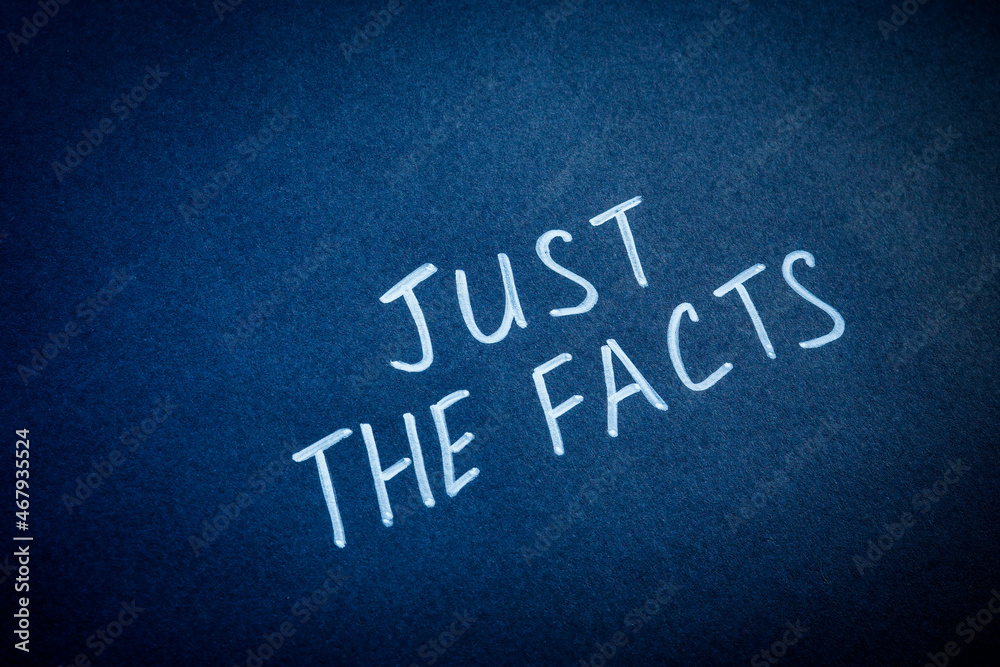 Handwritten words just the facts on the dark surface. Handwritten words just the facts on the dark surface.