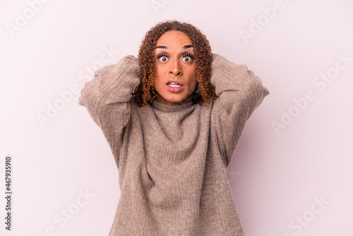 Young latin transsexual woman isolated on pink background screaming with rage. © Asier
