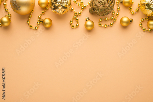 Fototapeta Naklejka Na Ścianę i Meble -  Top view photo of golden christmas tree balls and beard garland on isolated beige background with empty space