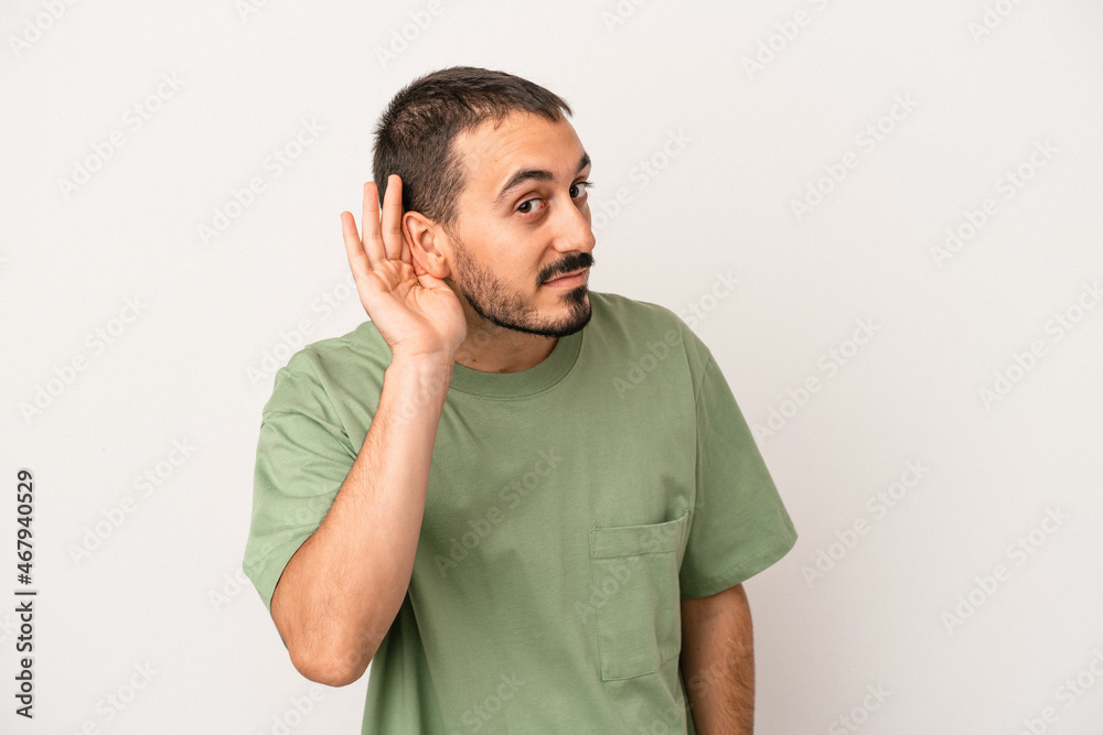 Young caucasian man isolated on white background trying to listening a gossip. Young caucasian man isolated on white background trying to listening a gossip.