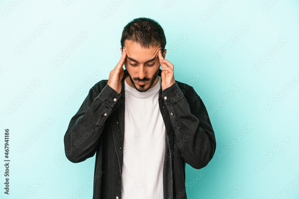 Young caucasian man isolated on blue background touching temples and having headache. Young caucasian man isolated on blue background touching temples and having headache.