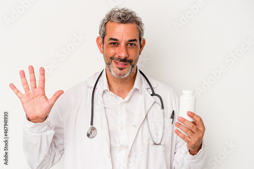 Middle age doctor caucasian man isolated on white background smiling cheerful showing number five with fingers.