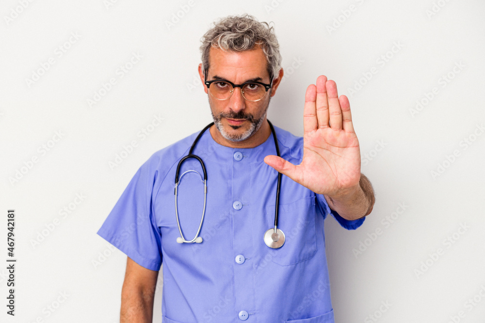 Middle age nurse caucasian man isolated on white background standing with outstretched hand showing stop sign, preventing you. Middle age nurse caucasian man isolated on white background standing with outstretched hand showing stop sign, preventing you.