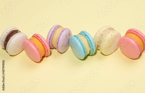 baked round macarons on a beige background, delicious dessert, top view