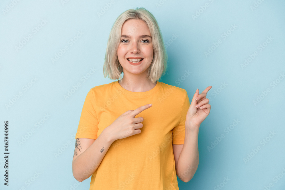 Young caucasian woman isolated on blue background excited pointing with forefingers away. Young caucasian woman isolated on blue background excited pointing with forefingers away.