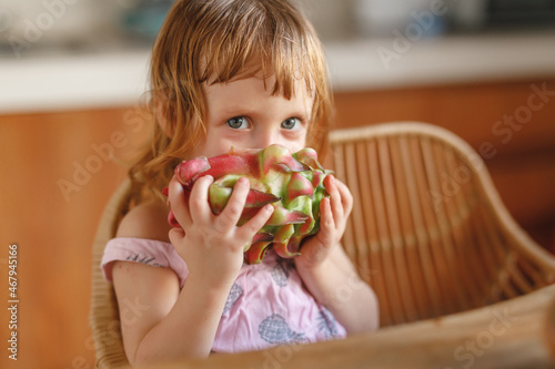 Cute little girl eat pitahaya tropical fruit photo