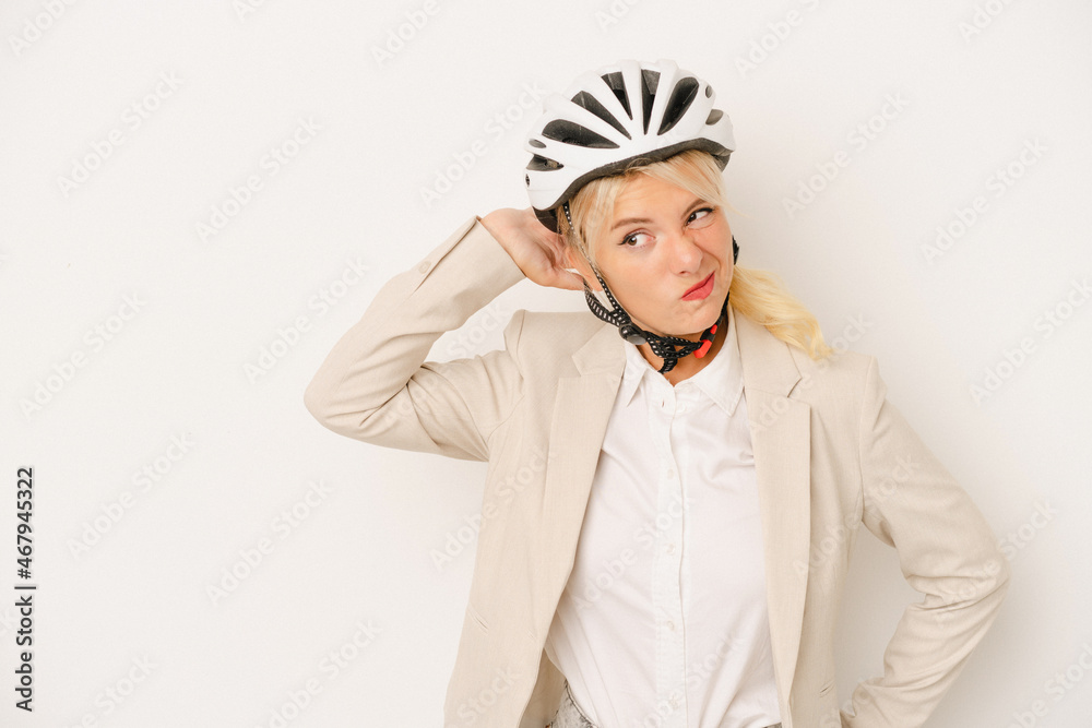 Young business Russian woman holding bike helmet isolated on white background touching back of head, thinking and making a choice.