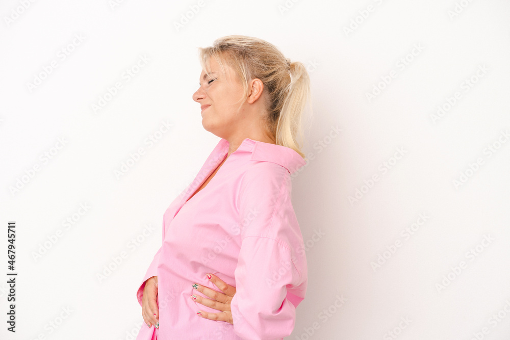 Young Russian woman isolated on white background suffering a back pain. Young Russian woman isolated on white background suffering a back pain.
