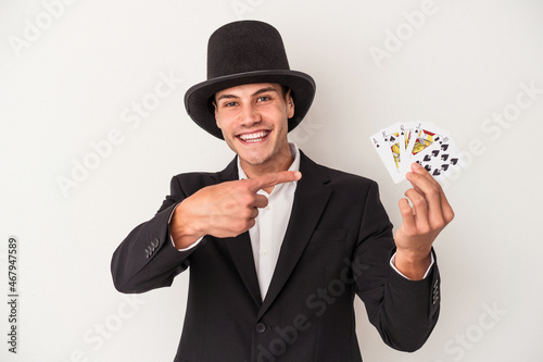 Young magician caucasian man holding a magic cards isolated on white background