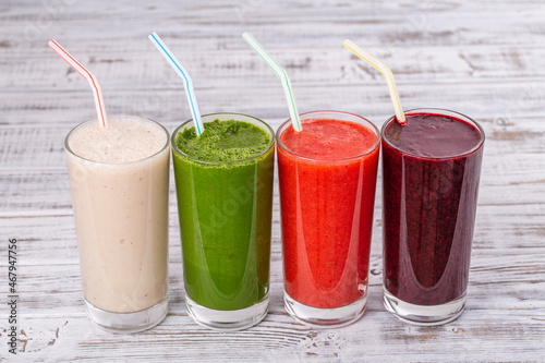 Fresh avocado, strawberry, blueberry and banana drinks on wooden table