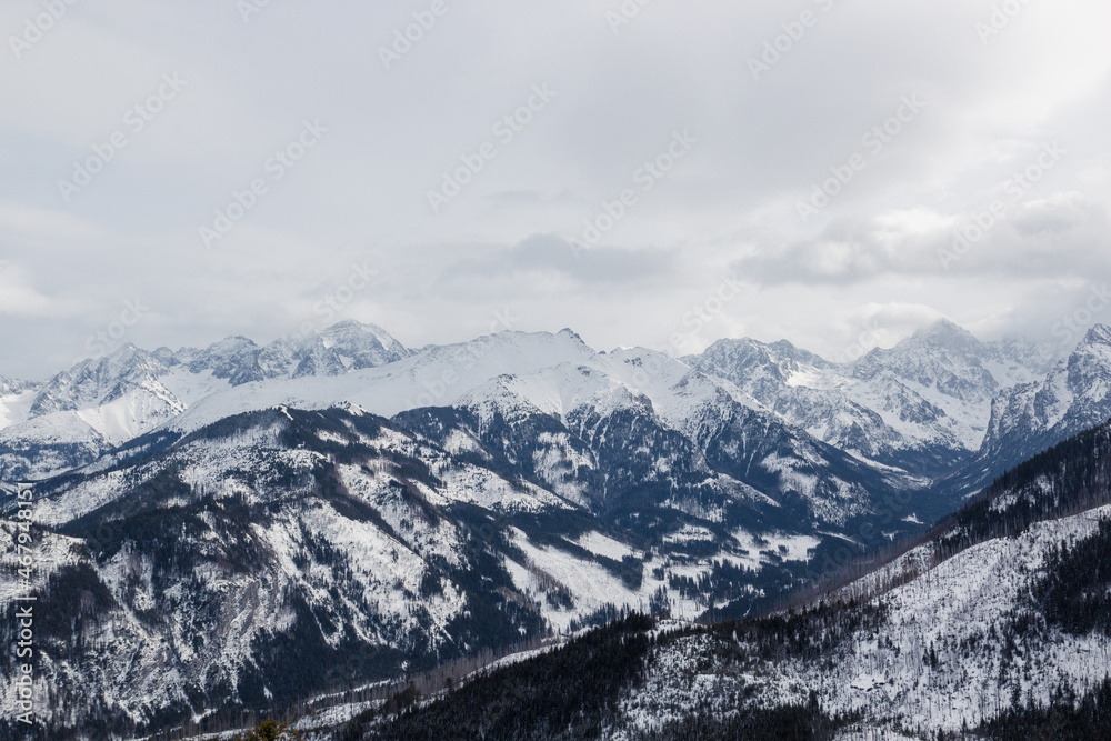 Panorama of snow capped mountains, snow and clouds