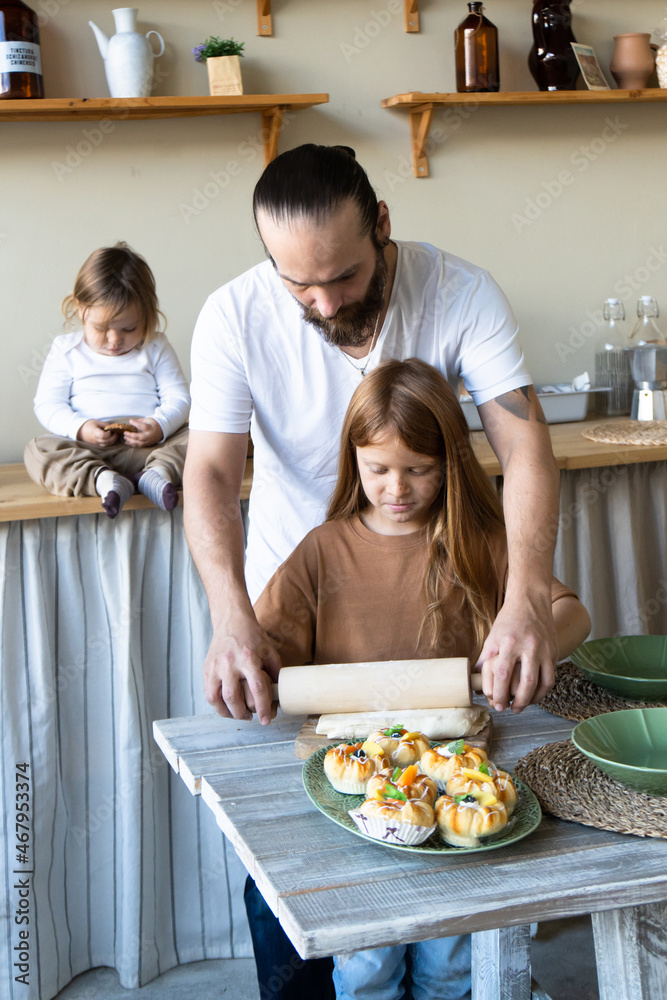 A family with three children has fun baking together.Dad And Daughter Laughing And Cooking Healthy Food Front View Lifestyle Concept . Candid
