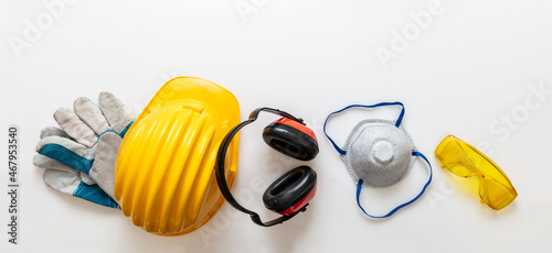 Safety equipment helmet gloves and ear muffs isolated on white background. Personal protective gear photo