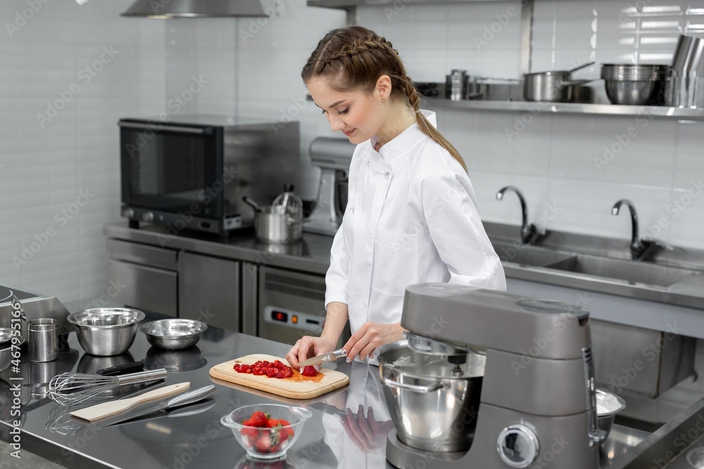 Pastry chef cuts strawberries for dessert Pastry chef cuts strawberries for dessert