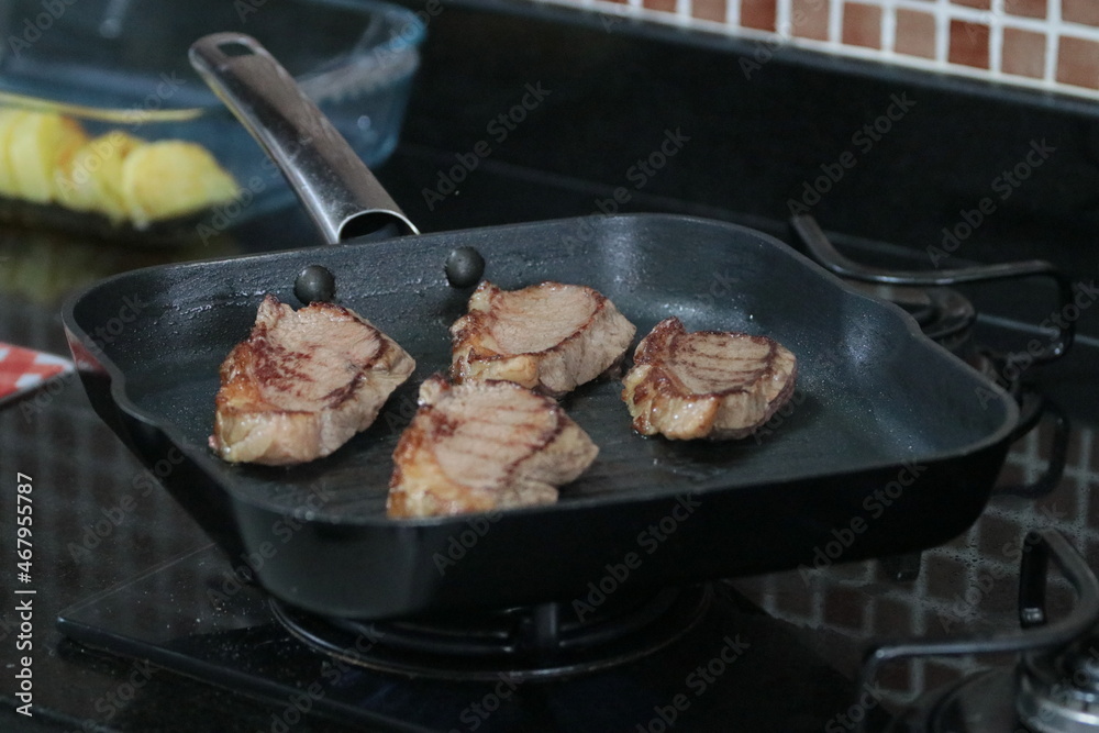 Peça de carne picanha inteira e com cortes crua e grelhada em frigideira Peça de carne picanha inteira e com cortes crua e grelhada em frigideira