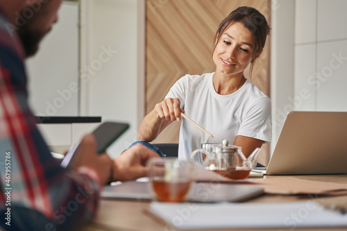 Happy smiling woman entrepreneur talking with unrecognized business partner in modern apartments