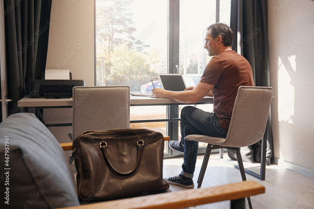 Serious aged man working online in office Serious aged man working online in office