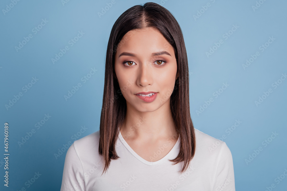 Photo of young attractive woman bite lips teeth flirty romantic feelings date isolated over blue color background