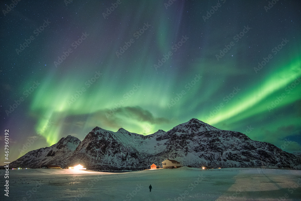 Aurora borealis, Northern lights over snow mountain range in skagsanden beach at Lofoten islands