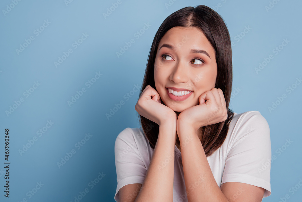 Photo of cute dreamy thoughtful lady hands cheeks look blank space on blue background Photo of cute dreamy thoughtful lady hands cheeks look blank space on blue background