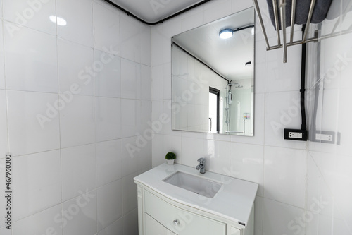 White bathroom with washbasin, faucet and mirror