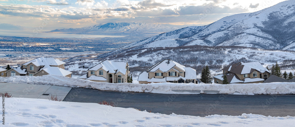 Uphill snowy residential area at Draper in Utah with a view of Wasatch mountains and lake