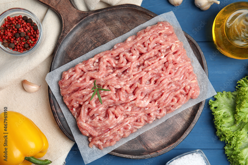 Raw chicken minced meat and ingredients on blue wooden table, flat lay Raw chicken minced meat and ingredients on blue wooden table, flat lay