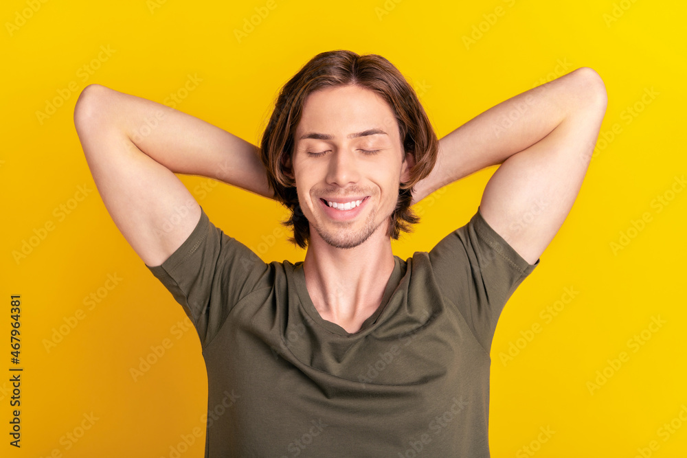 Top above high angle view photo of young guy happy positive smile hands behind head rest sleep isolated over yellow color background Top above high angle view photo of young guy happy positive smile hands behind head rest sleep isolated over yellow color background