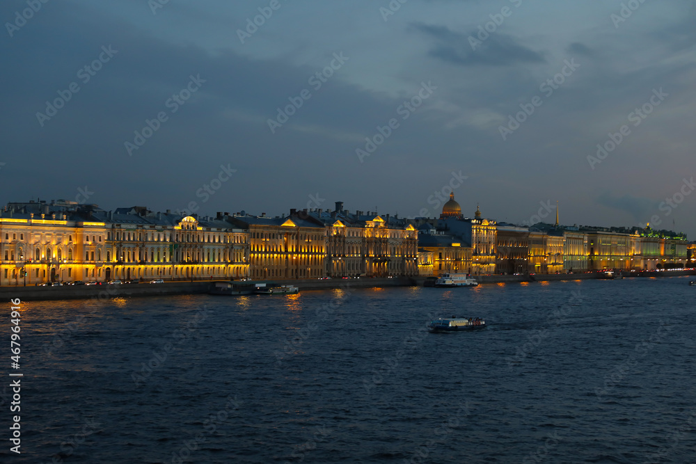 Fototapeta premium Night Panorama of Brightly Lit Buildings of the Embankment, Reflected in the Waters of the Neva River Modern St. Petersburg at Night