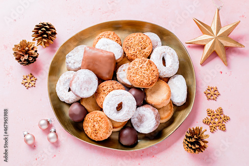 Holiday delicacies polvorones and mantecados in golden plate on pink table overhead photo