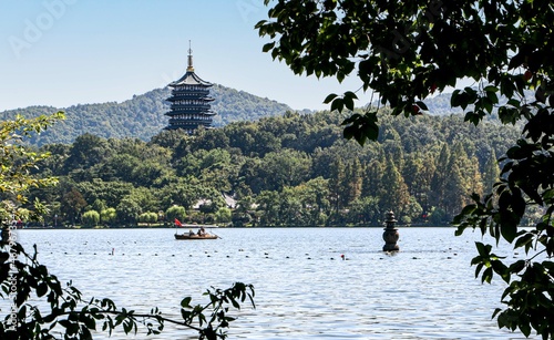 Beautiful landscape in the West Lake, Hangzhou, China, as a rowing boat passes the Leifeng Pagoda towering above one of the three pools mirroring the moon photo