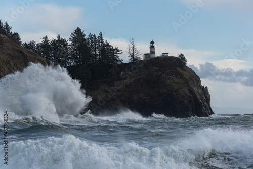 Powerful stormy ocean waves crashing under cliff and light house on the Washington Coast